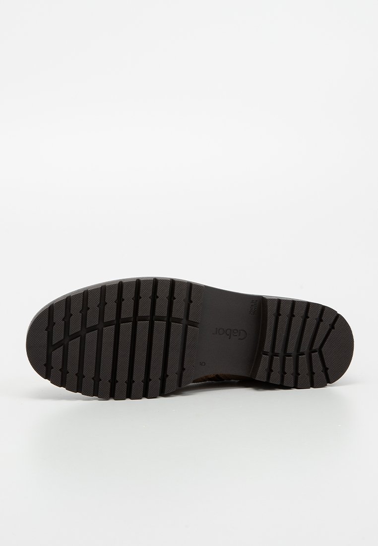 Czarna gumowa podeszwa buta z teksturowanym wzorem bieżnika. Posiada logo w pobliżu pięty oraz rowki zwiększające przyczepność. Płaska, trwała konstrukcja.