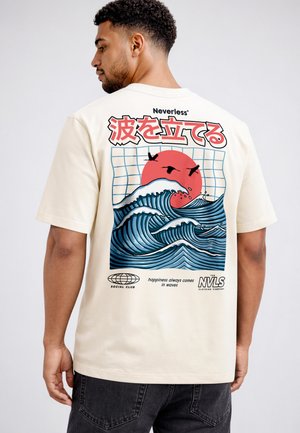 Man wearing beige T-shirt with graphic of stylized blue ocean waves, red sun, flying birds, and Japanese text on back.