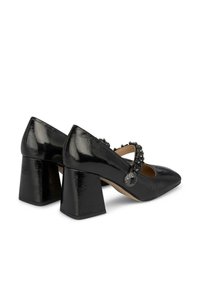 Zapatos de tacón alto negros con un acabado brillante, punta afilada, tacón grueso y una correa decorativa con adornos de cuentas.
