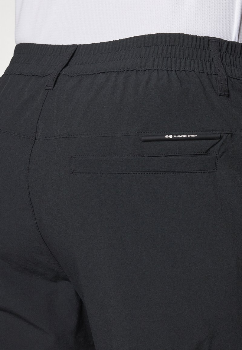 Shorts de sport noirs avec une texture douce, une taille élastique et une poche arrière avec un design épuré. Fabriqués en matériau respirant.