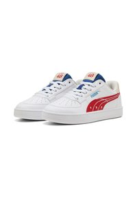 Baskets en cuir blanc avec des accents rouges et bleus, présentant des perforations sur les orteils, une languette rembourrée et un panneau latéral texturé avec un logo.