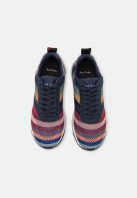 Sneakers multicolori con una tomaia in rete e strisce orizzontali nelle tonalità di blu scuro, rosa, verde e giallo. Lacci e dettagli in tessuto nero.