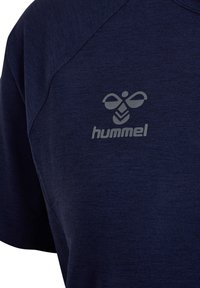 Granatowa koszulka sportowa z miękkiego materiału, z szarym logo hummel na piersi. Zaprojektowana z raglanowymi rękawami dla większej wygody.