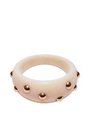 Beige chunky armbånd med jævnt fordelte runde gyldne nitter rundt om ydersiden.