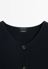 Laivastonsininen, raidoitettu puuvillaneuletakki V-kaula-aukkolla ja kahdella tummalla napilla edessä. Etiketissä lukee "100 % puuvillaa" ja "Massimo Dutti."