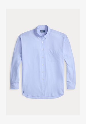 Camisa de manga larga color azul claro con cuello de botón, bolsillo frontal y logo bordado en la parte inferior izquierda. Textura de algodón suave.