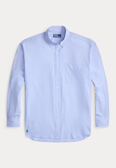 Svetlo modra srajca z dolgimi rokavi, s kragnjo na gumbe, sprednjim žepom in vezenim logotipom na spodnjem levem delu. Gladek bombažni material.