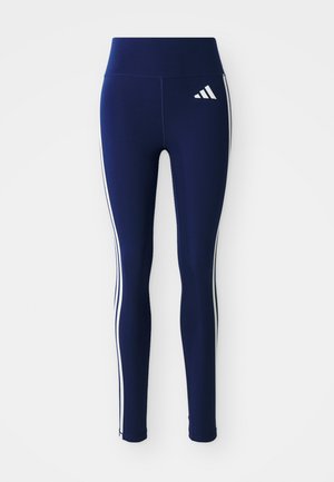 Marineblå leggings laget av elastisk stoff, med høy midje og hvite sidestriper. En liten hvit logo er synlig på den øvre låret.