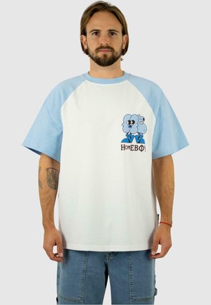 Weißes T-Shirt mit hellblauen Raglanärmeln; zeigt Cartoonfiguren und den aufgestickten Text "HOMEBOY" auf der Brust. Kurze Ärmel, lockere Passform.