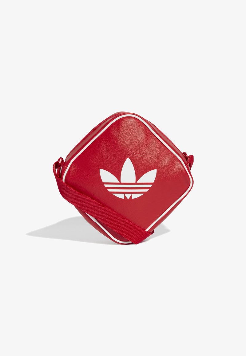 Borsa a tracolla rossa in pelle con accenti bianchi e logo. Forma a diamante, chiusura con zip, tracolla regolabile. Texture liscia, design sportivo.