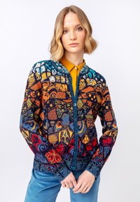 Barevný svetr s propracovanými geometrickými a květinovými vzory v modré, oranžové a červené barvě. Obsahuje kulatý výstřih a zapínání na knoflíky.