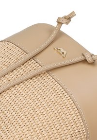 Bežová kabelka s tkanou texturou slámy a hladkými koženými akcenty. Obsahuje zlaté logo a kontrastní prošití. Nastavitelné popruhy.