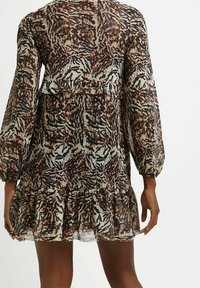 Vestido de manga corta con estampado animal en tonos marrón y negro, detalle de volantes en capas y una tela ligera y transparente.
