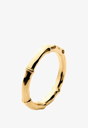Anillo de oro con un diseño texturizado inspirado en el bambú, superficie suave y reflectante, bordes redondeados, sobre un fondo blanco.