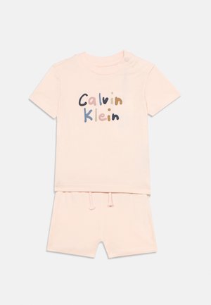 Σετ βρεφικό με κοντομάνικο ροζ πουκάμισο και σορτς, το πουκάμισο έχει πολύχρωμο κείμενο "Calvin Klein", τα σορτς διαθέτουν ελαστική μέση με κορδόνι.