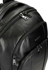 Czarny skórzany plecak z wieloma zamykanymi kieszeniami, teksturowane wykończenie i smukły design. Wyraźne akcenty ze srebrnych elementów.