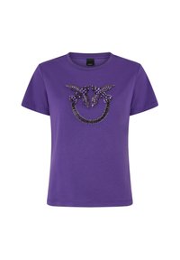 Ljubičasta pamučna majica s ukrasnim uzorkom crnih i ljubičastih ukrasa u stiliziranom dizajnu sprijeda. Kratki rukavi.