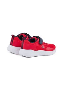 Chaussures de sport rouges avec une partie supérieure en maille texturée, un arrière rouge uni, une semelle en caoutchouc blanche et une sangle en Velcro bleu marine à l'avant.