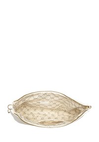 Crèmekleurige leren tas met gouden accenten, met een gladde buitenkant en een gestreepte, crème kleurige voering met zwarte geometrische designs.