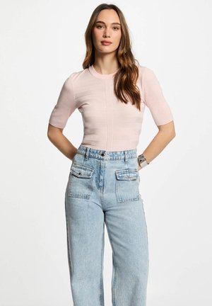 Lichtroze geribde crop top met korte mouwen en een ronde halslijn, gecombineerd met high-waisted blauwe denim jeans met voorzakken.