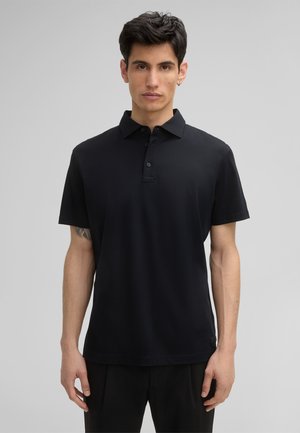 Polo noir en tissu lisse, avec un col et un plastron à trois boutons. Manches courtes et coupe décontractée.