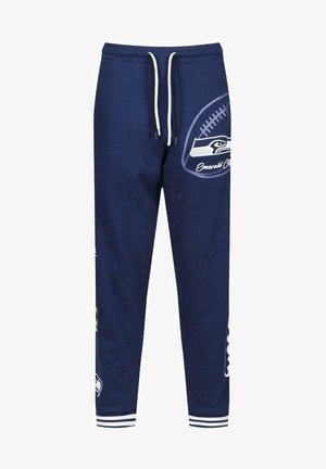 Pantaloni della tuta blu navy con coulisse bianca, con una grafica di football e logo della squadra sulla gamba destra. Polsini a coste alle caviglie.