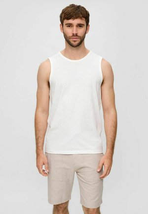 Weiße ärmellose Tanktop aus leichtem Stoff, kombiniert mit beigen Shorts, die zwei Vordertaschen und ein schlichtes Design aufweisen.