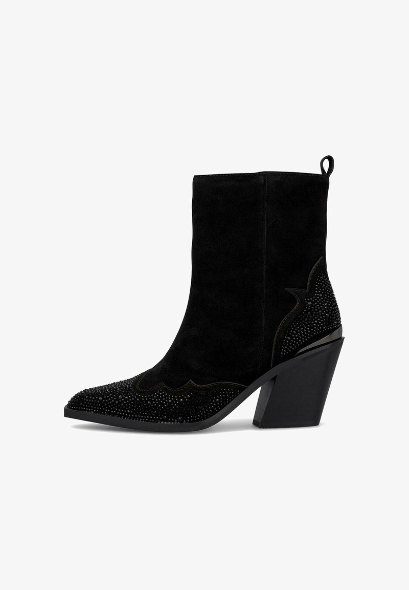 Bota de tobillo de ante negro con punta afilada, diseño decorativo en forma de ondas y adornada con gemas negras en la punta y el tacón.