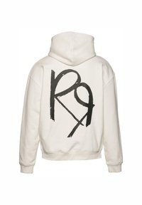 Hættetrøje i off-white stof med et stort sort grafisk logo på ryggen. Har ribbede manchetter og kant. Blød tekstur.