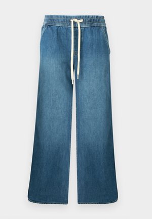 Pantalon en jean bleu à jambes larges avec taille élastique et cordon blanc, deux poches latérales, sans marque visible.