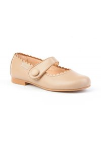 Zapato de cuero beige con punta redonda, bordes ondulados y una sola correa ajustable con cierre de botón redondo. Suela plana de goma.