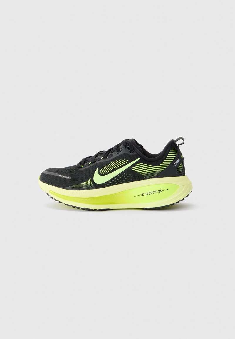 Chaussure de course noire avec des accents vert néon, tige en mesh pour la respirabilité, semelle texturée et marque "zoomx" sur le côté.