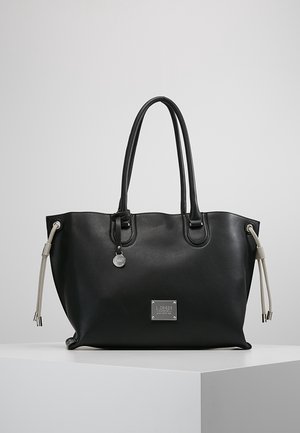 Sac fourre-tout en cuir noir avec deux poignées, plaque de marque argentée à l'avant, et détails à cordon beige de chaque côté, présenté sur un socle blanc.