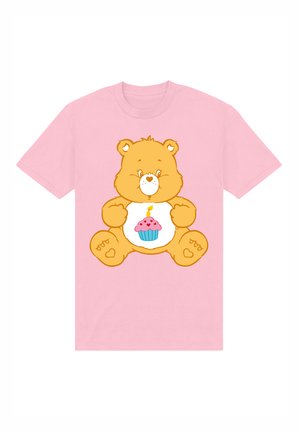 T-shirt rosa con un orso cartone animato dal corpo arancione e un design di cupcake sul pancione, dettagliato con una candela e accenti colorati.