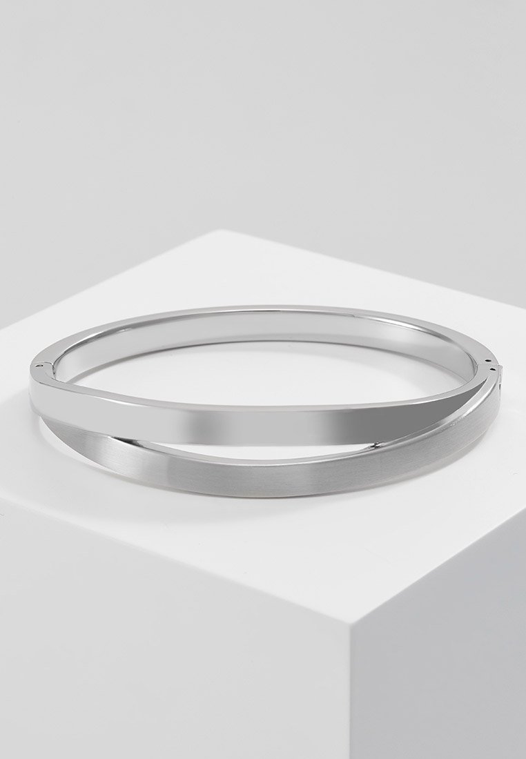 Brățară din argint sub formă de bangle, având două benzi împletite, una lustruită și reflectorizantă, iar cealaltă periată pentru textură. Formă rotundă, margini netede.