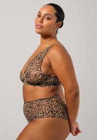 Completo intimo in stampa leopardata, composto da un reggiseno a scollatura profonda e mutande a vita alta. Entrambi i pezzi presentano bordi scallop e un tessuto morbido e testurizzato.