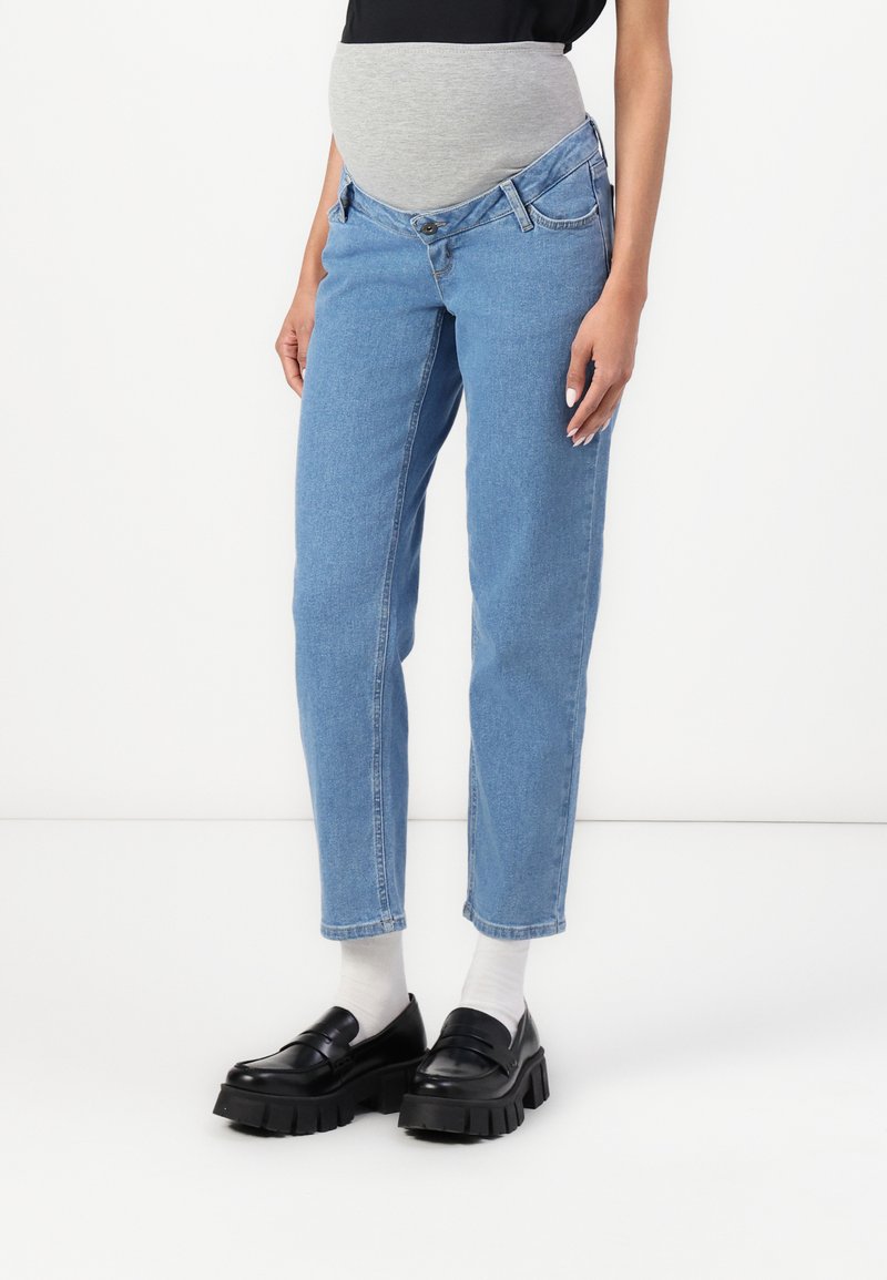 Jeans premaman in denim blu chiaro con una fascia grigia elasticizzata sopra il pancione, caratterizzati da un design classico a cinque tasche e gambe dritte.