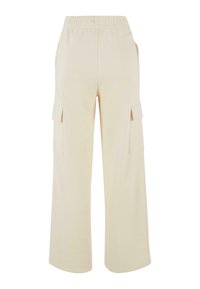 Pantalon cargo beige à coupe décontractée, avec une ceinture élastique, deux poches latérales et une texture douce et lisse. Pas de motifs visibles.