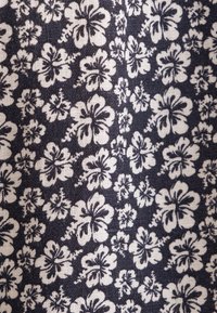 Tessuto blu navy con un motivo floreale bianco caratterizzato da fiori di hibiscus, distribuiti uniformemente sulla superficie con una finitura testurizzata.