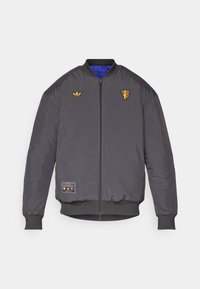Kull bomberjakke med blå inderside. Har guld broderede logoer og lynlås lukning. Ribbet manchetter og kant. Holdbart stof.