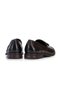 Zapatos de vestir de cuero marrón con detalles de brogue, punta redondeada y tacón apilado. Presentan una textura suave y acentos de color oscuro.