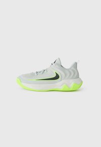 Chaussure de sport gris clair avec un design ondulé, accents noirs et semelle vert fluo. Présente un dessus texturé et un système de laçage.