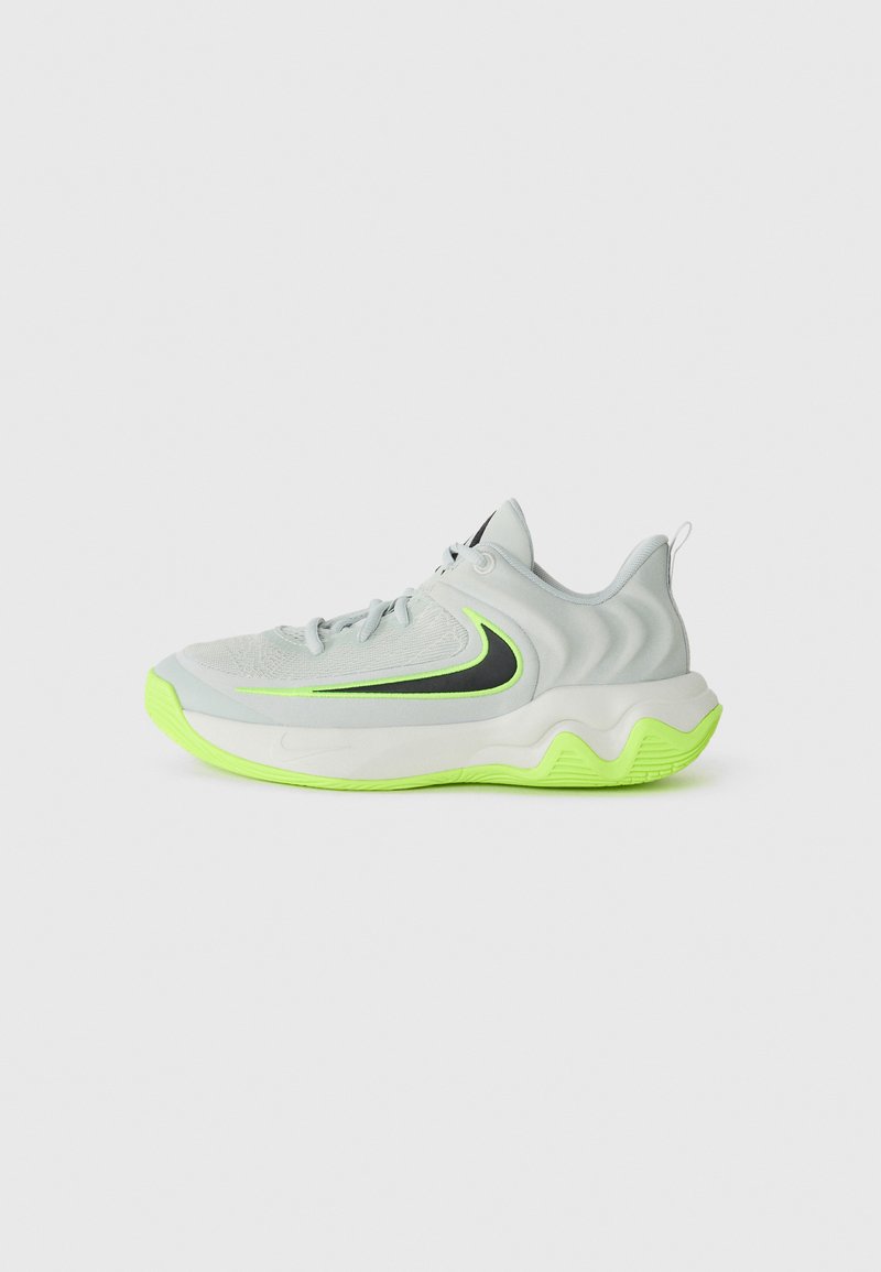 Chaussure de sport gris clair avec un design ondulé, accents noirs et semelle vert fluo. Présente un dessus texturé et un système de laçage.