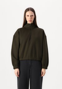 Dark green sweatshirt with a high collar and half-zip. Features drop shoulders, elastic cuffs, and a cinched waist. Cotton blend material.