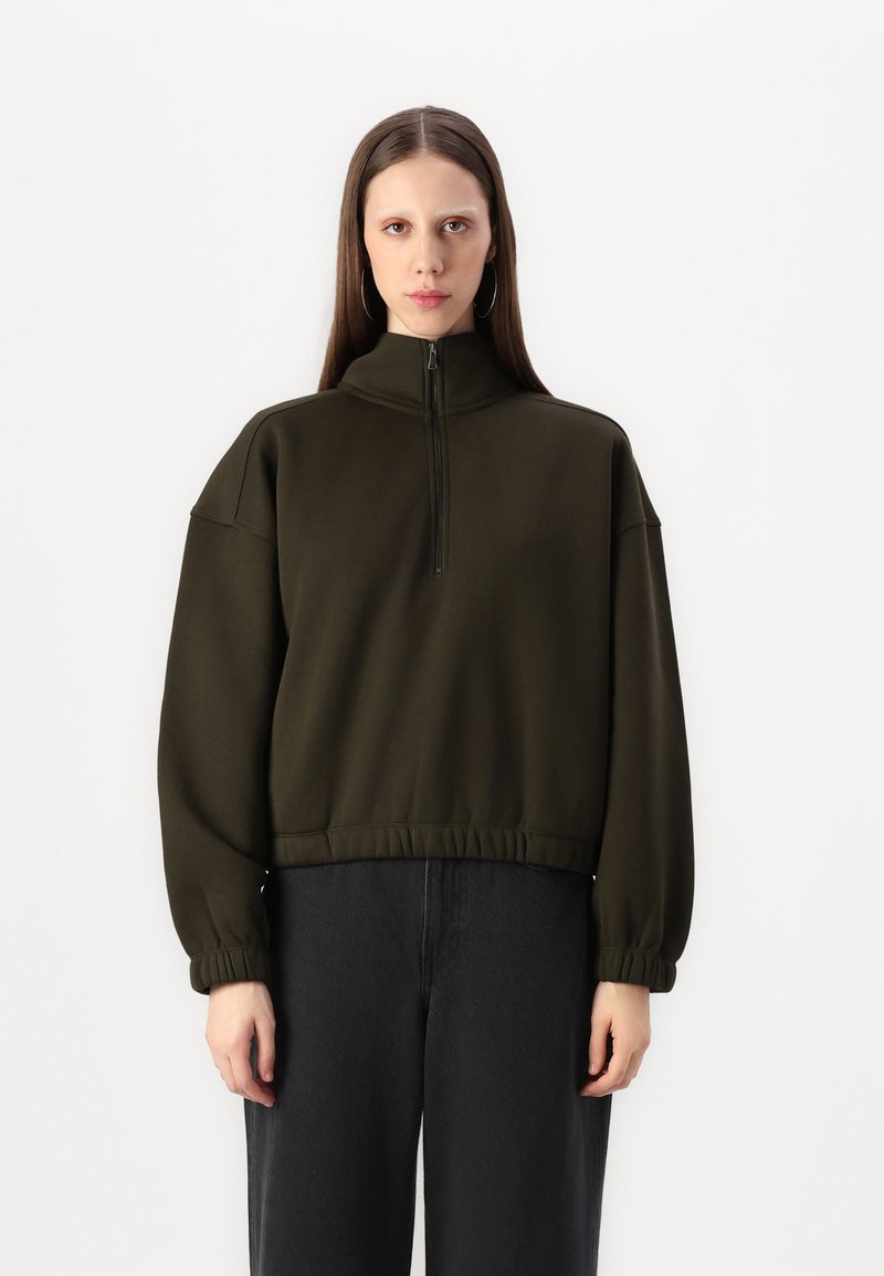 Dark green sweatshirt with a high collar and half-zip. Features drop shoulders, elastic cuffs, and a cinched waist. Cotton blend material.