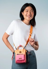 Sac bandoulière compact en orange, rose et jaune. Dispose d'une poignée supérieure, d'une sangle réglable et d'une poche zippée à l'avant. Design texturé et moderne.