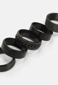 Sett med fem svarte armbånd med ulike design: glatte, blanke, teksturerte, kjede-link og vevet nett. Ulike bredder og overflater.