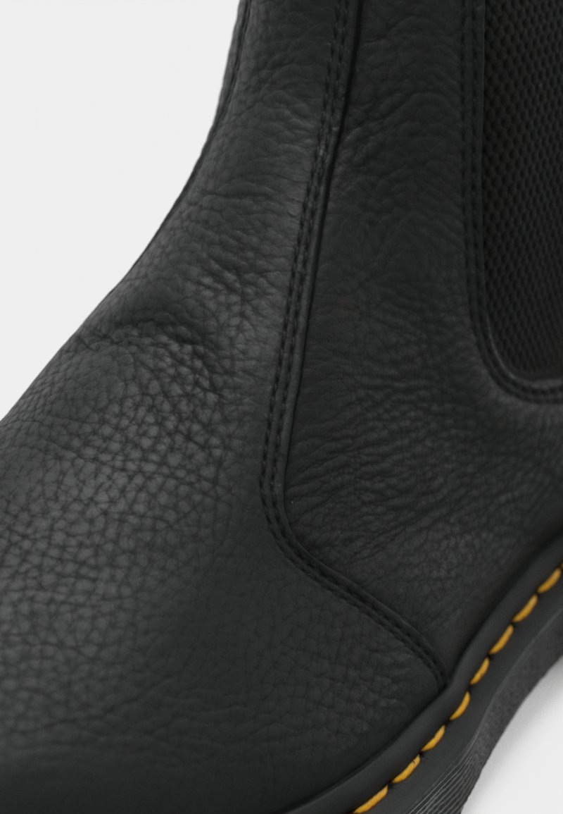 Black textured leather Chelsea boot with elastic side panel and yellow stitch detailing on the sole edge.