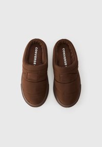 Καφέ παπούτσια slip-on με επενδεδυμένο υφασμάτινο άνω μέρος, που διαθέτουν ραμμένο σχέδιο και υφασμάτινη σόλα με υφή. Λογότυπο εκτυπωμένο στο εσωτερικό.