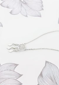 Sølv halskæde med en cirkulær vedhæng, der har et blomsterudskæring. Fint er der vedhængte skinnende perler og rektangulære accenter, der hænger fra en delikat kæde.